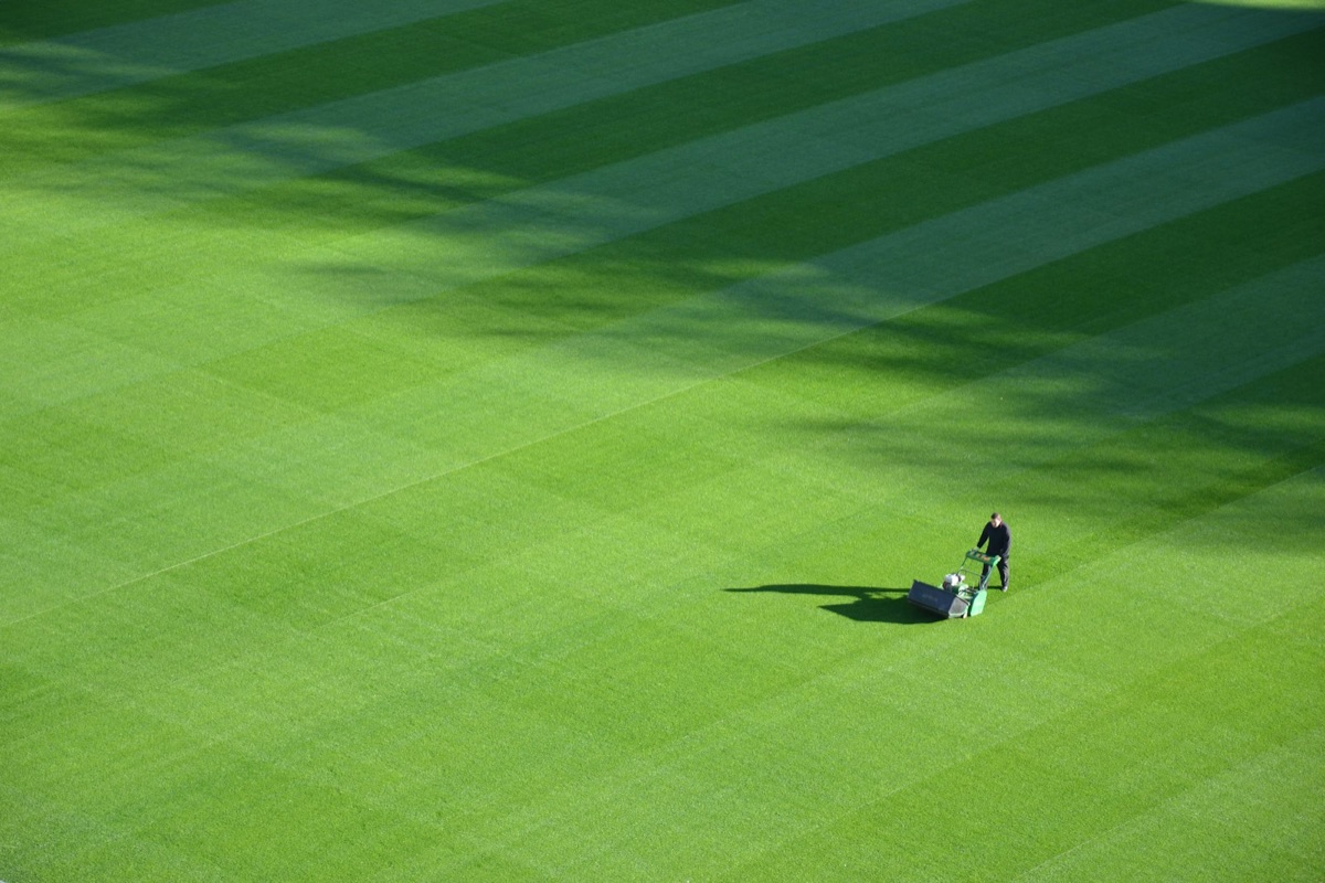 Aerial view of a mower trimming a sports field